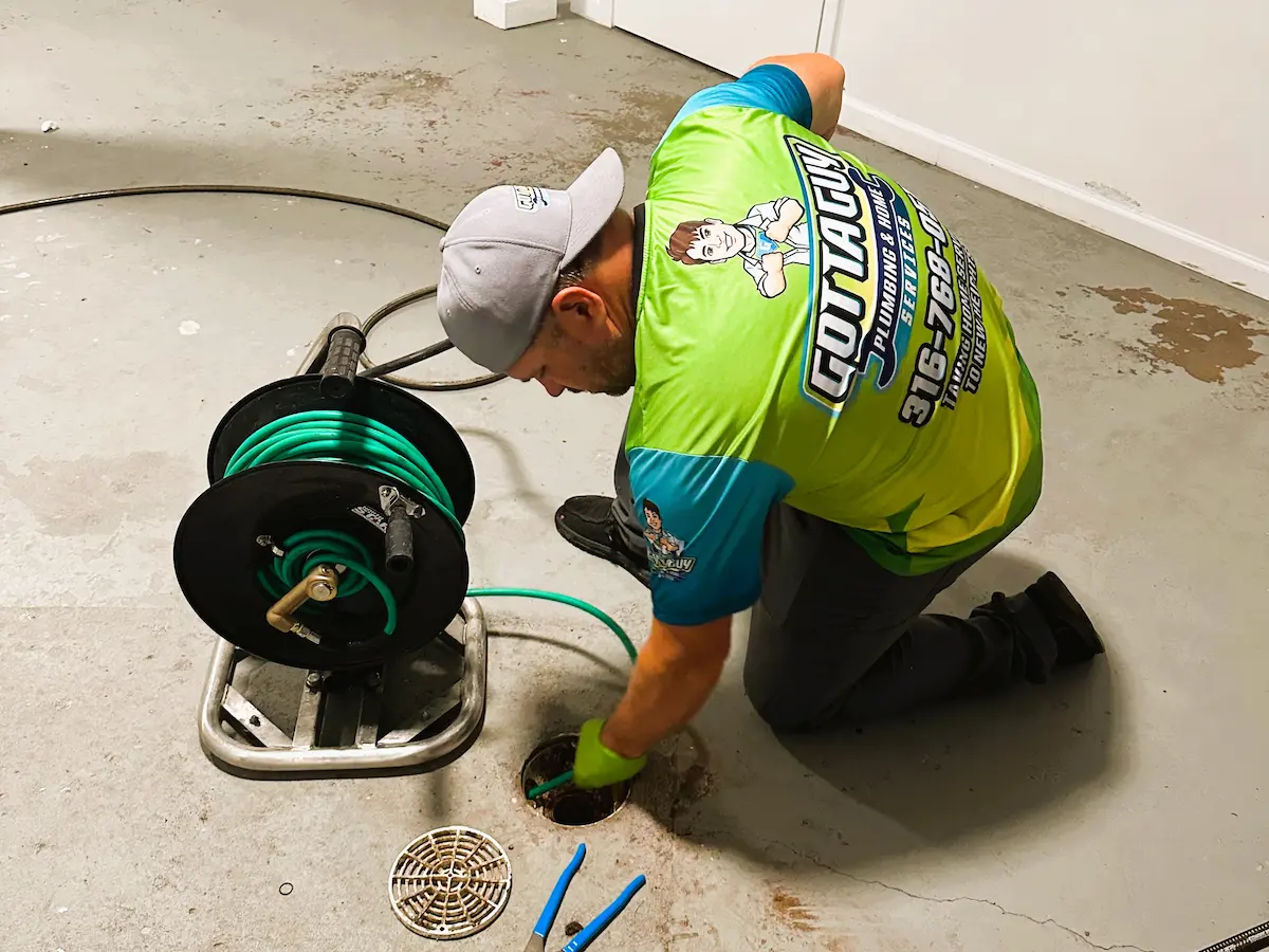 Plumber performing hydro jetting drain cleaning